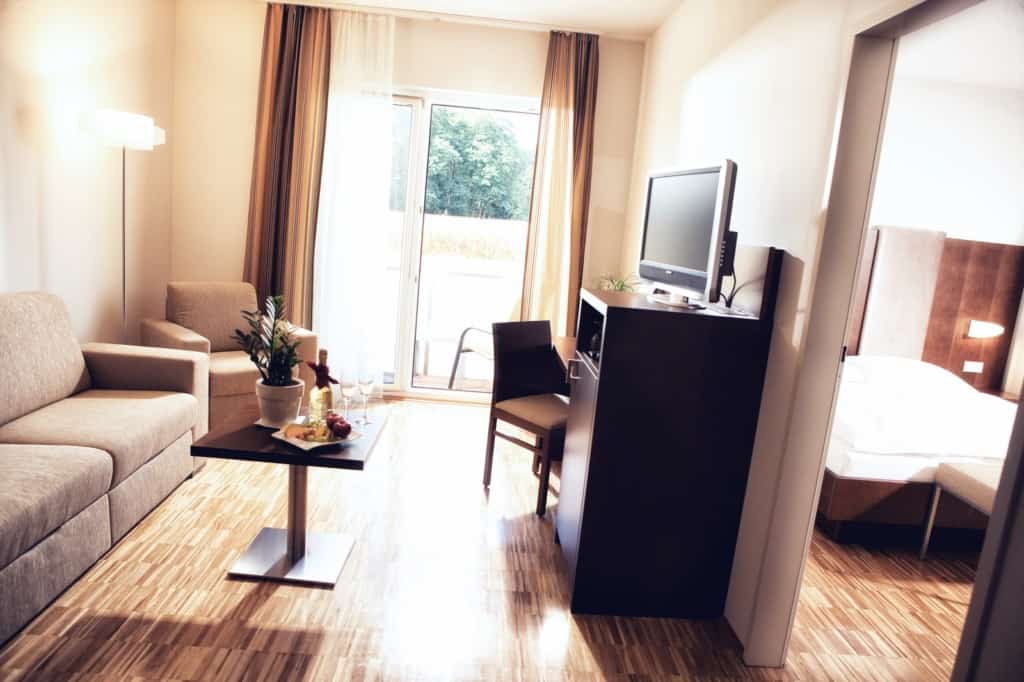 Bright junior suite with 2 rooms with balcony, comfortable seating, and flat-screen TV for a relaxing stay.