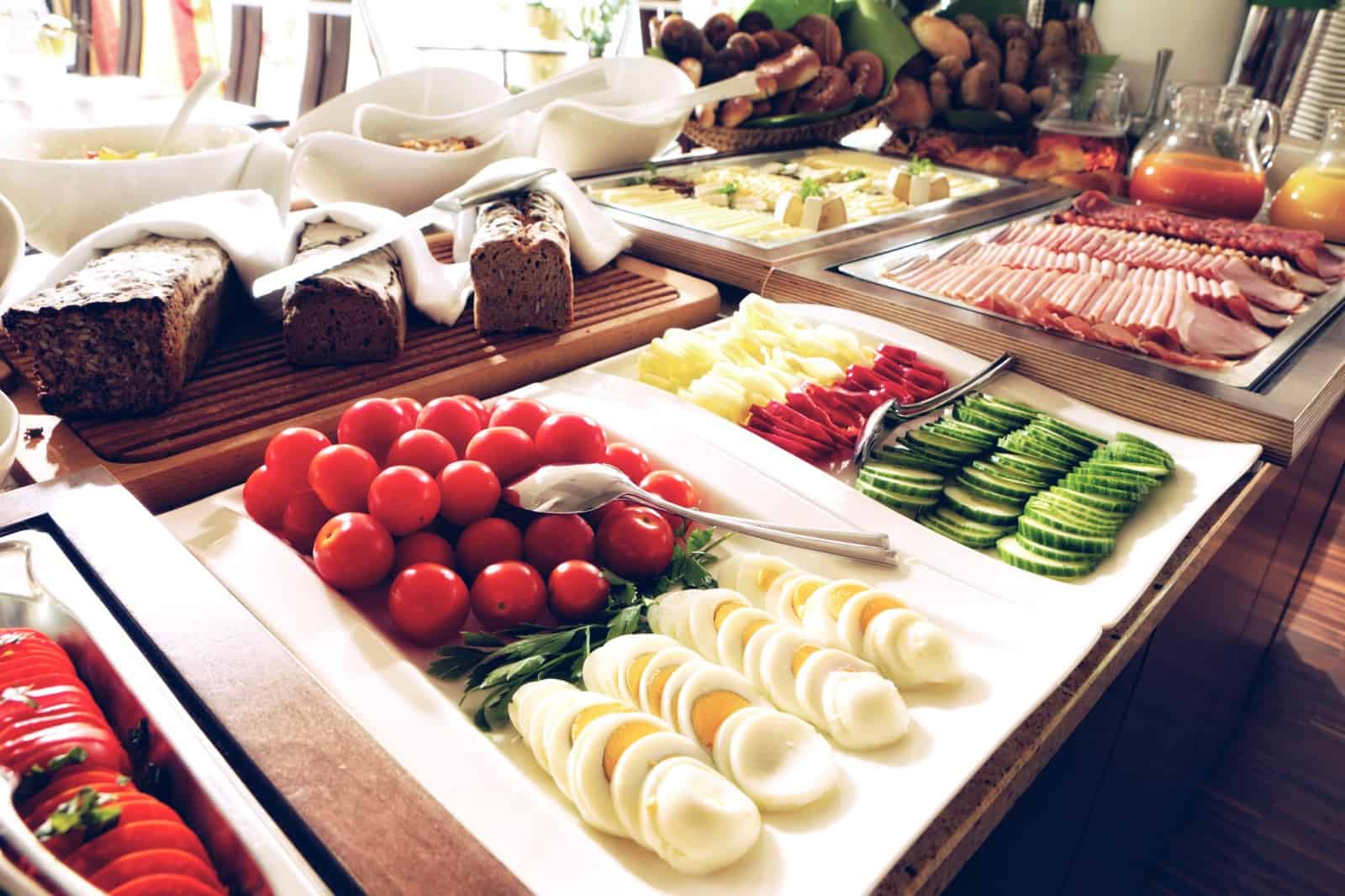 Rich breakfast buffet with bread, cold cuts, fruits, and beverages at Hotel Toscanina in Radkersburg.