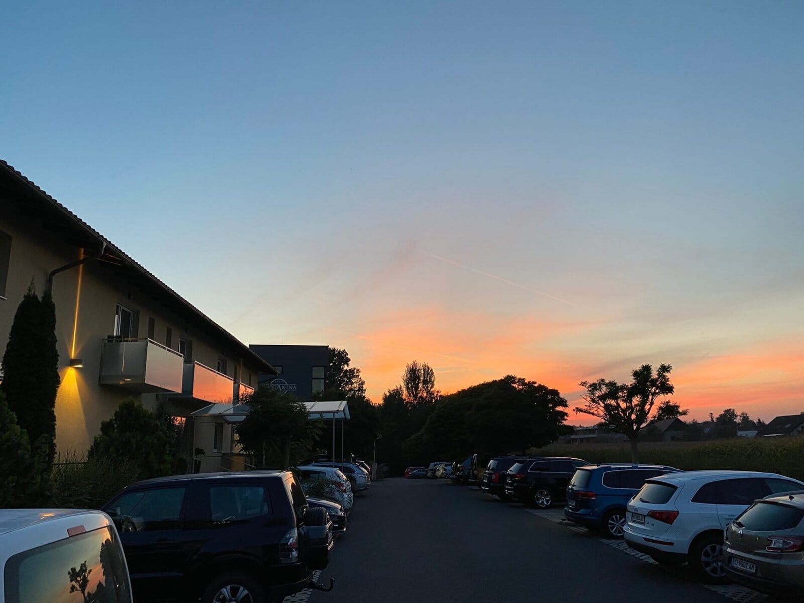Schöner Sonnenuntergang über dem Hotel Toscanina mit Parkplätzen und Naturkulisse.