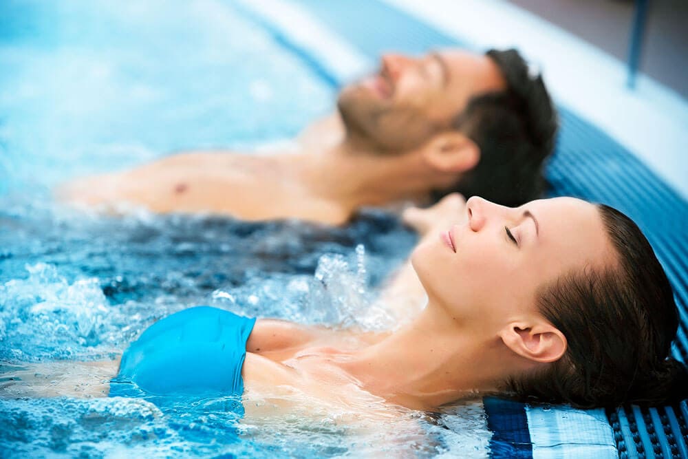 Paar entspannt im Thermalbad des Hotel Toscanina, ideal für Thermen-Pakete.