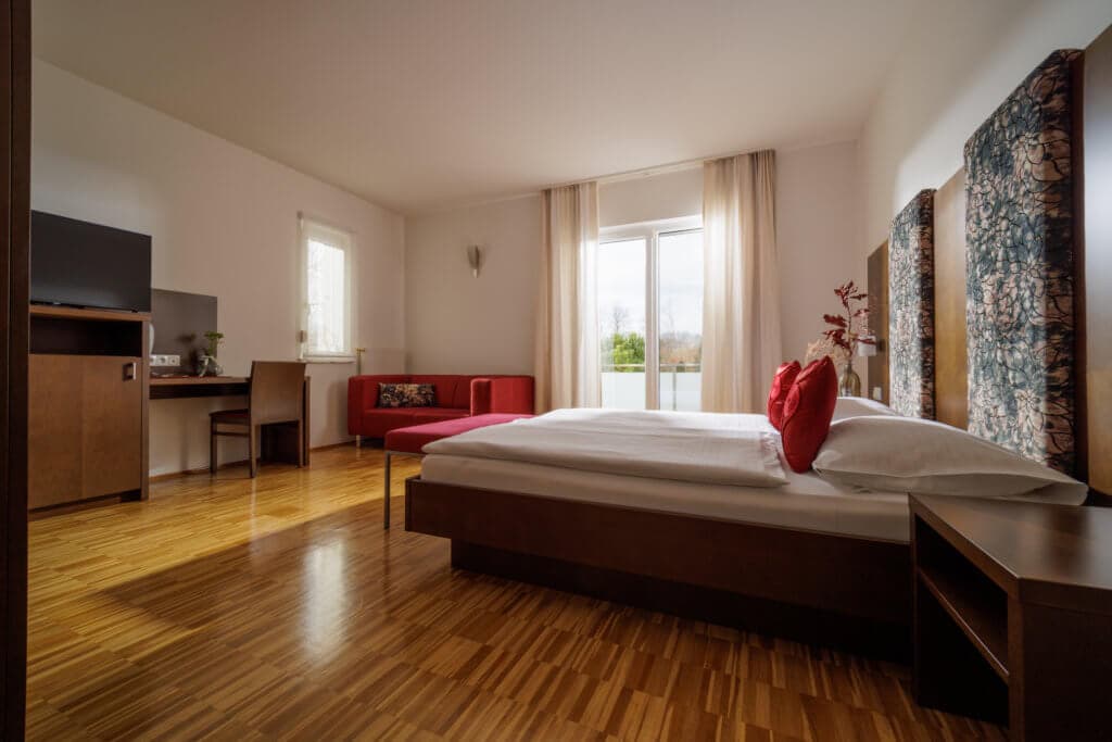 Zimmer mit Pool- und Gartenblick im Hotel Toscanina mit gemütlicher Einrichtung und Blick auf die Natur und den Pool-Garten