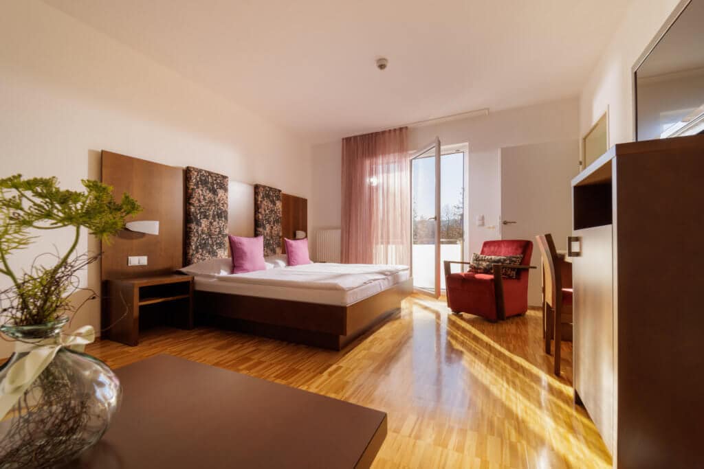 Helles Hotelzimmer mit Balkon, modern eingerichtet, ideal für Ihren Aufenthalt in der Toskana.