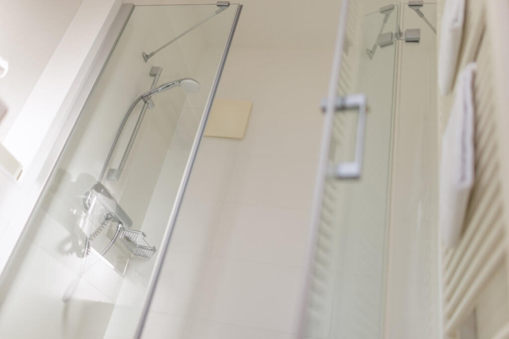 Badezimmer im Hotel Toscanina mit moderner Dusche und Badewanne.