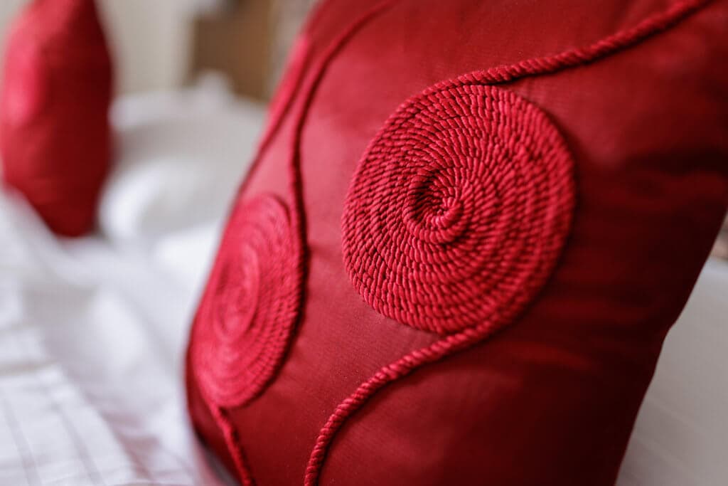 Gemütliches Hotelzimmer mit rotem Kissen, ideal für Ihren Aufenthalt.
